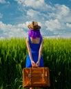 Girl with suitcase standing at wheat field Royalty Free Stock Photo