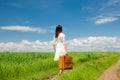 Girl with suitcase at wheat field Royalty Free Stock Photo