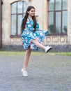 Girl summer dress flutters in motion urban background, active child concept