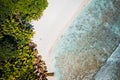 Girl sunbathing on tropical cocos beach with beautiful rocks, palm trees and ocean waves. Aerial drone shot. Seychelles