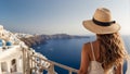 girl in a sundress and a hat with her back to the camera looks at the sea Santorini Greece Royalty Free Stock Photo