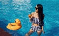 Girl in sunglasses have fun and rest in swimming pool at daytime Royalty Free Stock Photo