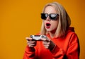 Girl in sunglasses keen plays with a joystick Royalty Free Stock Photo