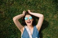 Girl with sunglasses lying on the grass in summer day in city park Royalty Free Stock Photo