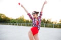 Girl in sunglasses and red swimsuit posing with holding lollipop Royalty Free Stock Photo