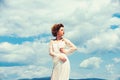 Girl on sunny blue sky background in summer. Fashion woman model pose outdoor. Beauty and fashion look in vintage style Royalty Free Stock Photo