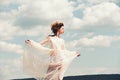 Girl on sunny blue sky background in summer. Pretty girl in white wedding dress and retro hairstyle. Fashion woman model Royalty Free Stock Photo