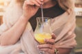 Girl on a sunny day in a cafe drinking a refreshing orange juice through a straw