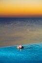 Girl in Sunset infinity pool