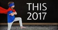 Girl in superhero costume standing near a board with 2017 new year quotes Royalty Free Stock Photo