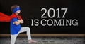 Girl in superhero costume standing near a board with 2017 new year quotes Royalty Free Stock Photo