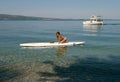 Girl with surf desk and boat Royalty Free Stock Photo