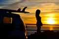 Girl and surfboard silhouettes at sunset Royalty Free Stock Photo