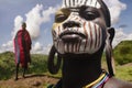 Girl from the Suri tribe poses for a photo with a traditionally painted face. Ethiopia