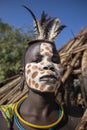 Girl from the Suri tribe poses for a photo with a traditionally painted face. Ethiopia