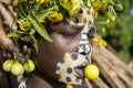 Girl from the Suri tribe poses for a photo with a traditionally painted face. Ethiopia