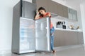 The girl is surprised at the empty refrigerator. Lack of food. Food delivery Royalty Free Stock Photo
