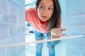 The girl is surprised at the empty refrigerator. Lack of food. Food delivery Royalty Free Stock Photo