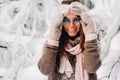 A girl in a sweater and glasses in winter in a snow-covered forest