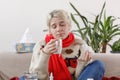 The girl in the sweater is sick and holds a mug with a hot drink. Colds and flu. The patient caught a cold, feeling sick.