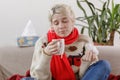 The girl in the sweater is sick and holds a mug with a hot drink. Colds and flu. The patient caught a cold, feeling sick.