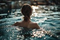 girl swimming in the evening pool back view Royalty Free Stock Photo