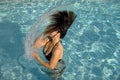 Girl in a swimming pool throwing wet hair Royalty Free Stock Photo