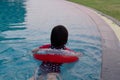 The girl is swimming with a red lifebuoy ring in one of the hotel`s pools Royalty Free Stock Photo