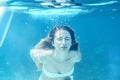 Girl swimming underwater portrait. Sea summer blue water background with bubbles sunny ray of lights