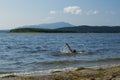 A girl swims in a picturesque lake, spraying water Royalty Free Stock Photo