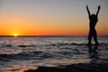 The girl swims in the sea, splashes in the water at sunset. Relaxation and happy pastime. Summer vacations