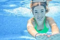 Girl swims in swimming pool underwater, happy active teenager dives and has fun under water, kid fitness on family vacation Royalty Free Stock Photo