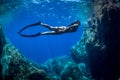 A girl swims underwater in apnea