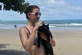 a girl in a swimsuit on the beach with a black cat