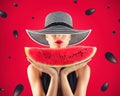 Girl in swimsuit with watermelon in hand and red background with seeds Royalty Free Stock Photo