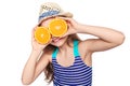 Girl in swimsuit making fake eyeglasses with oranges