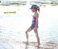 a girl in a swimsuit walks along the river bank on a sunny day,beach family vacation by the river Royalty Free Stock Photo