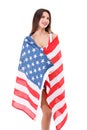 Girl wrapped up in an American flag and looking upwards on a white isolated background Royalty Free Stock Photo
