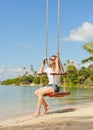 Girl on a swing against the background tropical seasca Royalty Free Stock Photo