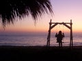Girl on swing on beach at sunrise in Vama Veche resort at the Black Sea in Romania