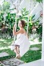 Girl on a swing in a summer tropical garden Royalty Free Stock Photo