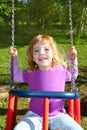 Girl swinging on swing happy in meadow grass park Royalty Free Stock Photo