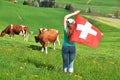 Girl with the Swiss flag against cows Royalty Free Stock Photo
