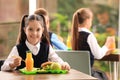 Girl at table with healthy food in school canteen