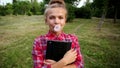 Girl with tablet pc blew up bubble from chewing gum