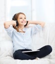 Girl with tablet pc and headphones at home