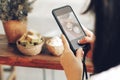 A girl take a picture some food by smartphone in restaurant