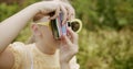 girl take pictures with insta camera and yellow retro dress and modern glasses