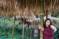 girl take portrait under thatched roof