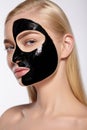 Girl takes off black cosmetic mask from her face.
